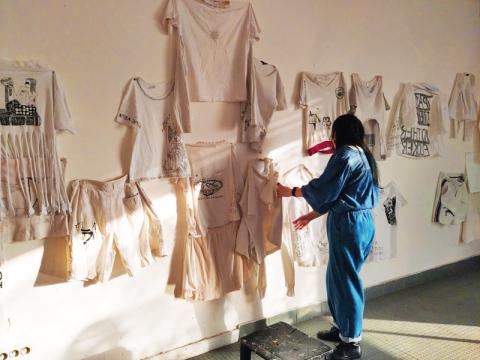 Photographie d'un atelier macSUP, des vêtements blancs sont accrochés sur les murs.